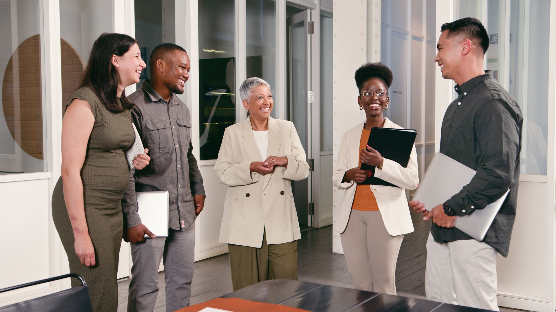 Professional Team Engaging in Friendly Discussion in a Modern Office Environment